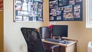 A home office with a desk, computer, and a bulletin board filled with photos. - Econo Lodge Inn & Suites Rockmart (Rockmart)