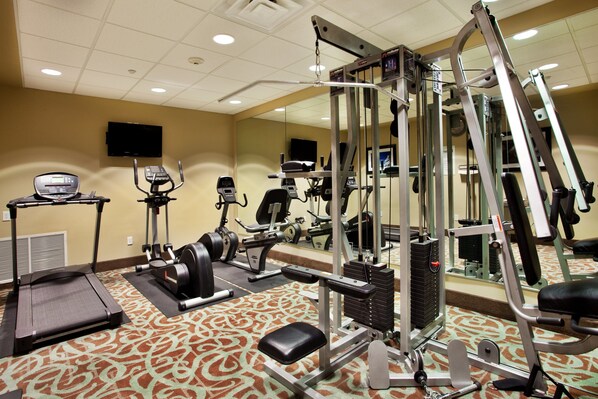 A gym with treadmills, elliptical machines, and weightlifting equipment.