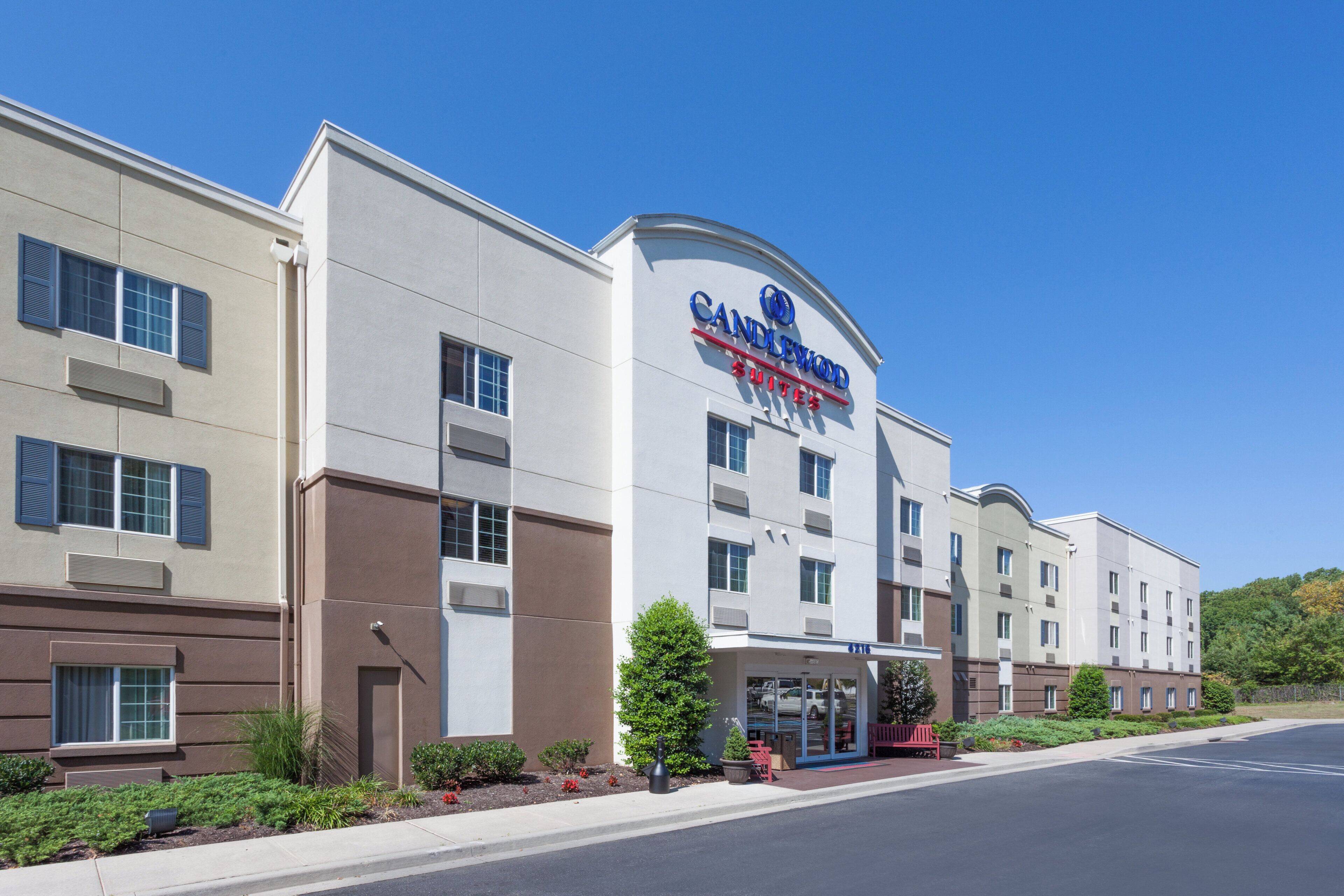 A hotel with a modern facade, multiple windows, and a clear sky.