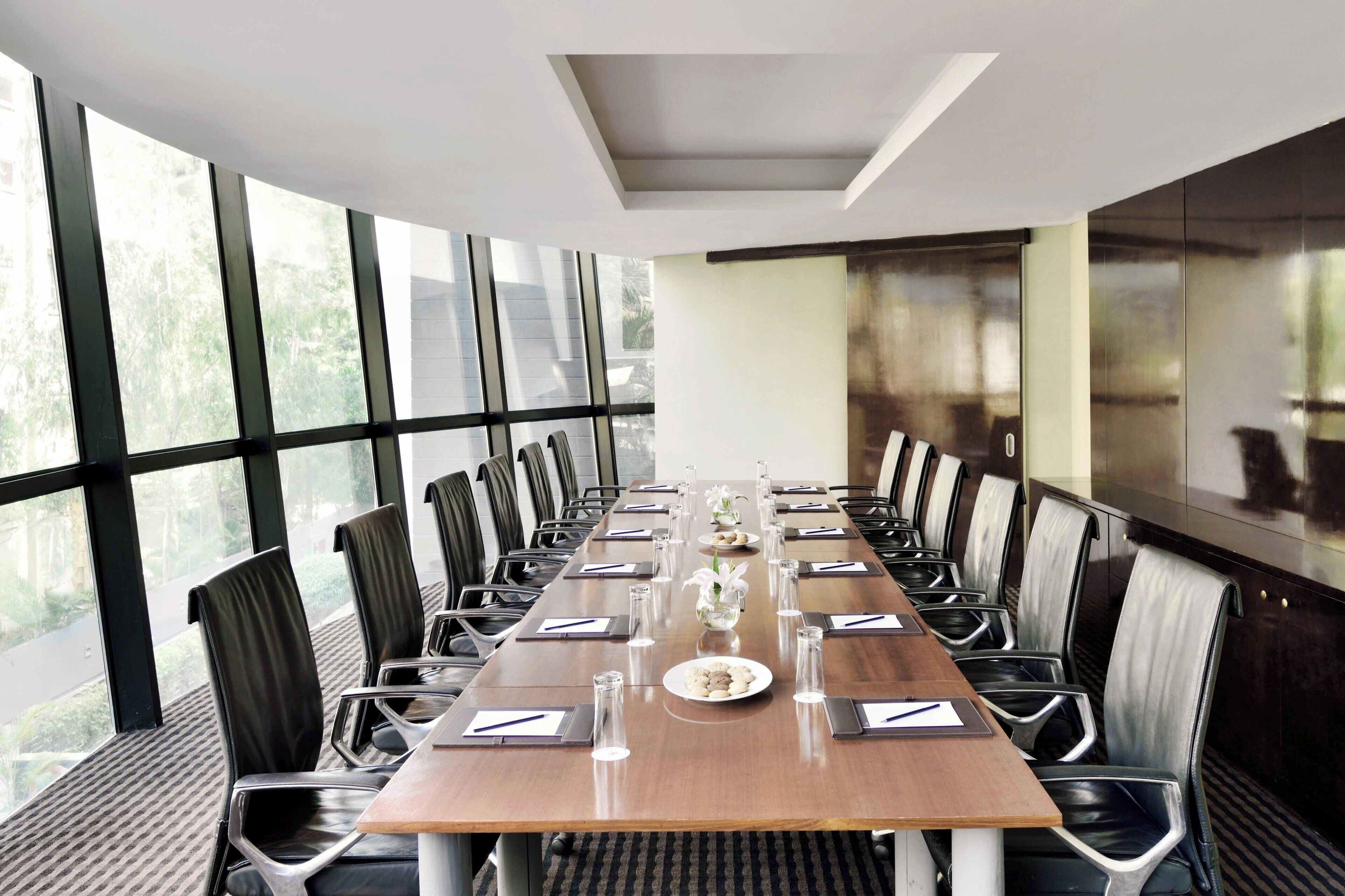 A conference room with a long table, chairs, and a large window.