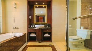 A modern bathroom with a large mirror, a freestanding bathtub, a sink with a vessel basin, and a toilet. - Beijing Bao Lin Xuan International Hotel (Beijing)