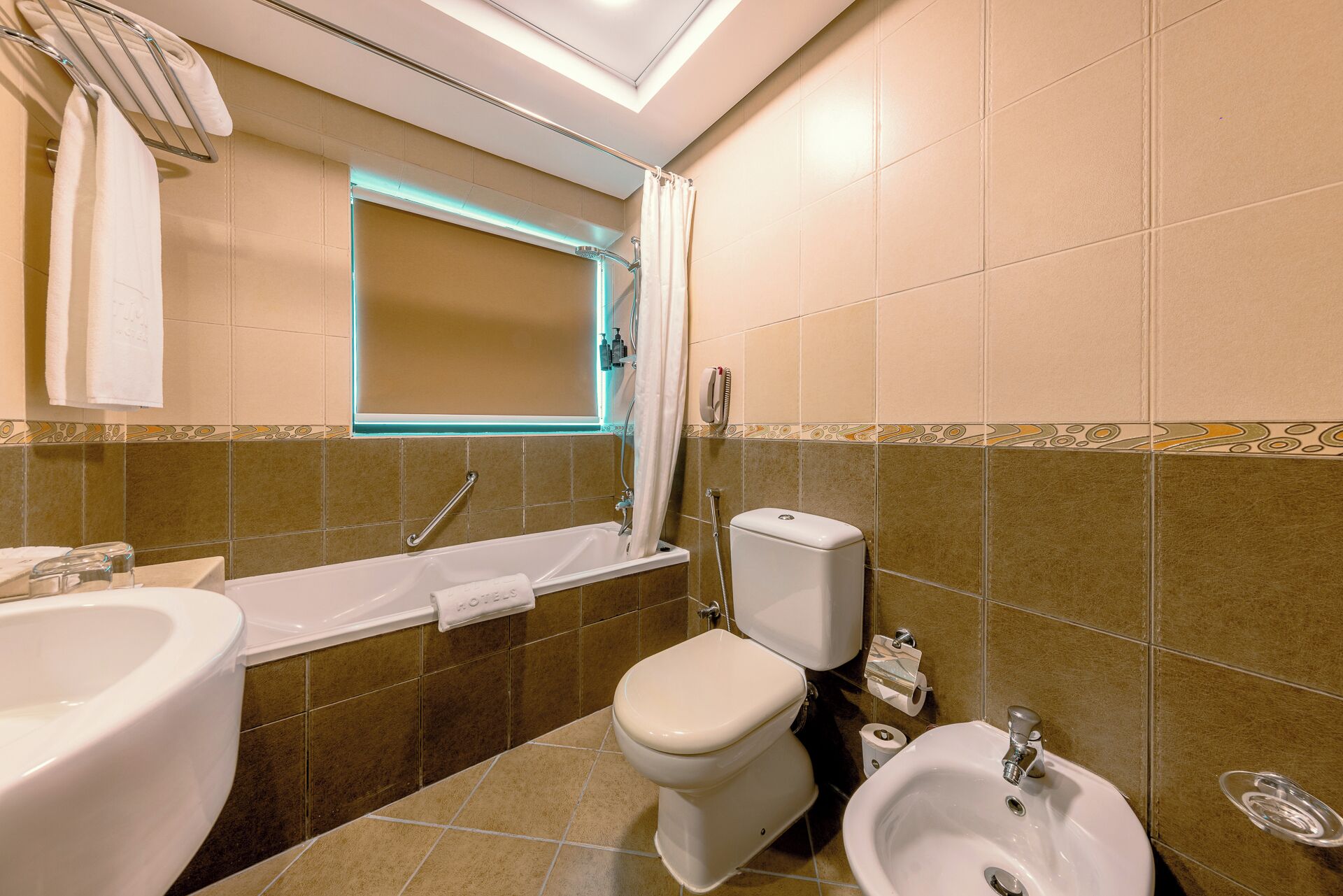 Un baño con bañera, inodoro, lavabo y bidé.