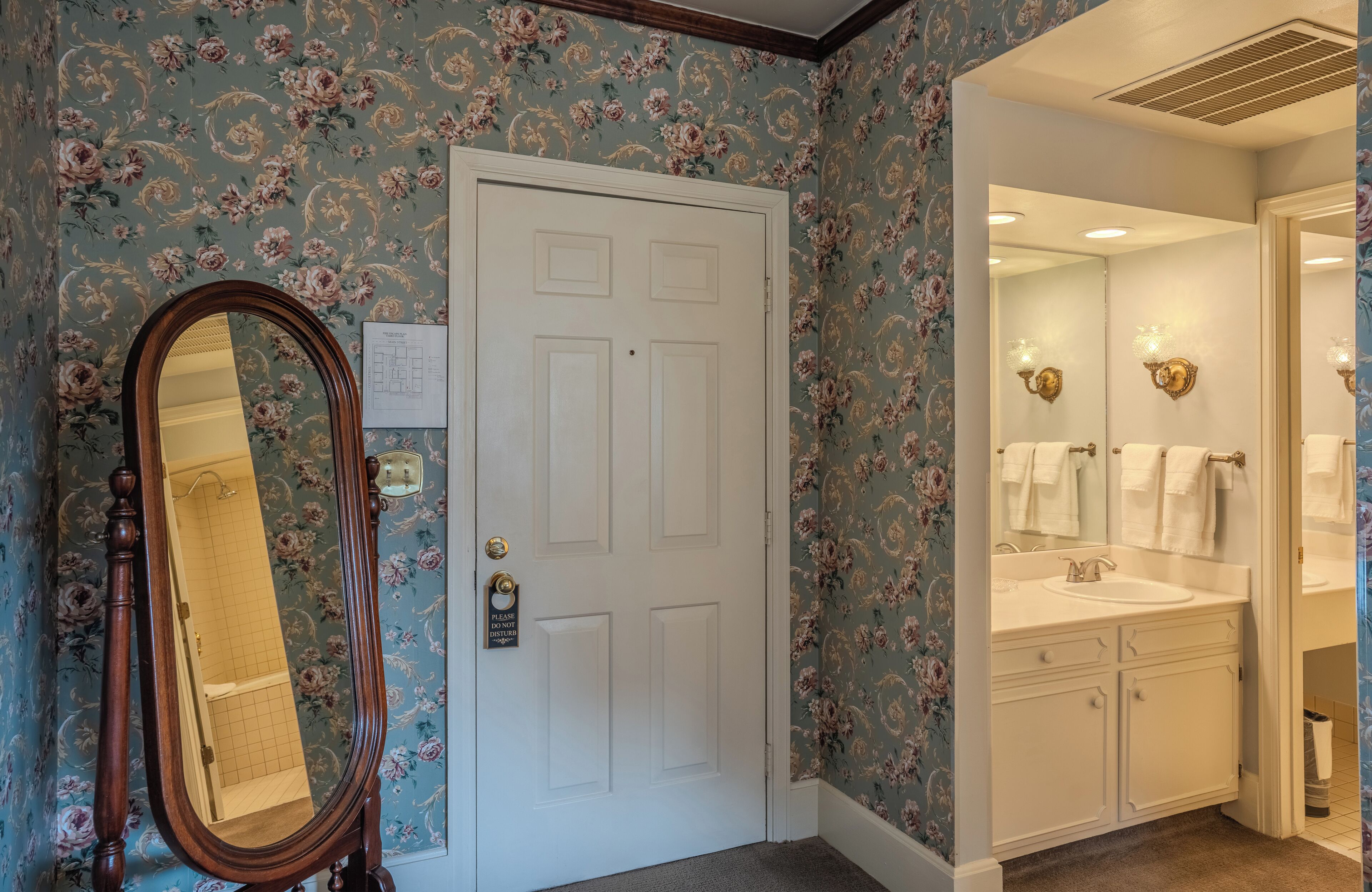 A bathroom with a white sink, mirror, and towel rack.