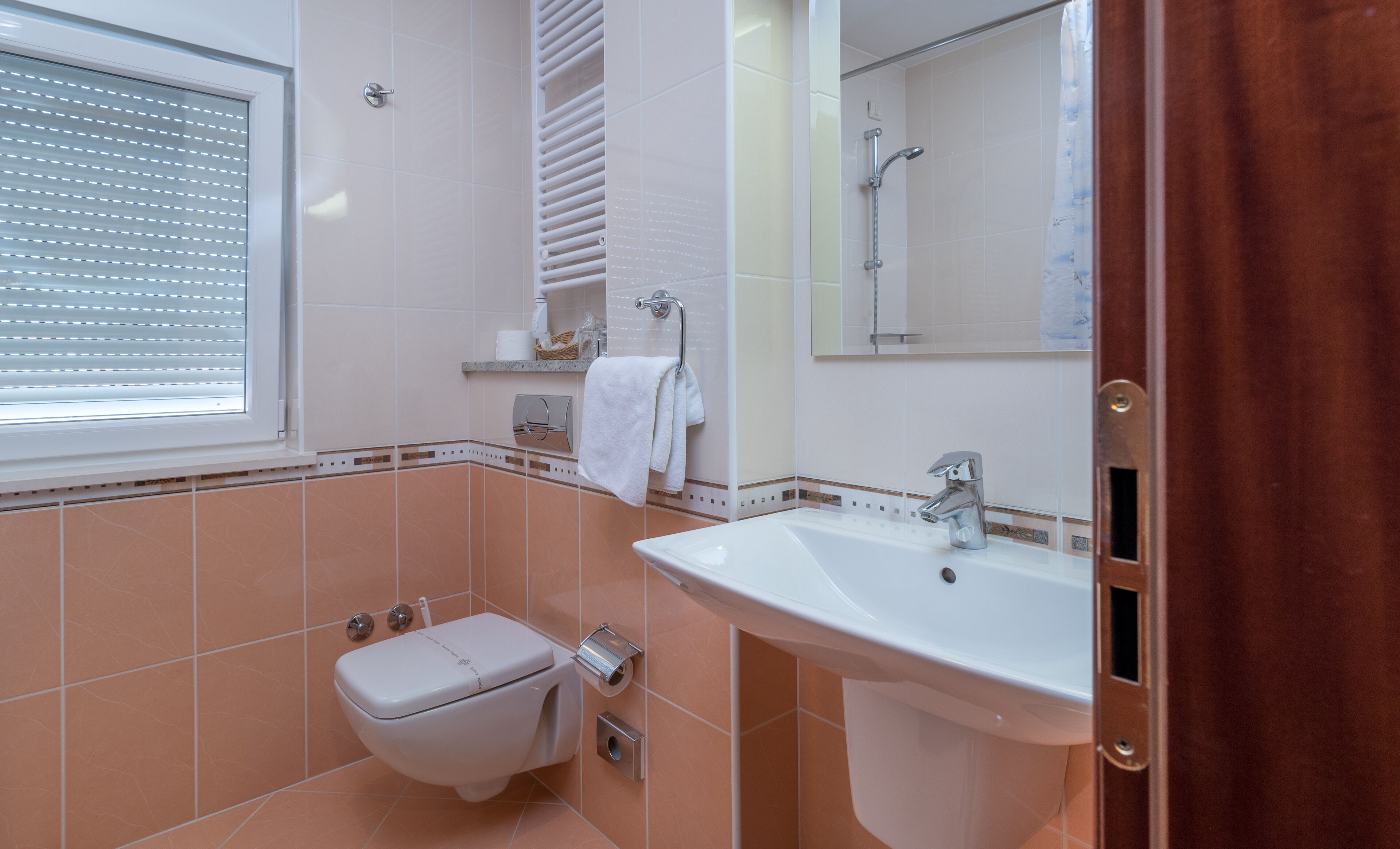 A bathroom with a toilet, sink, and shower.