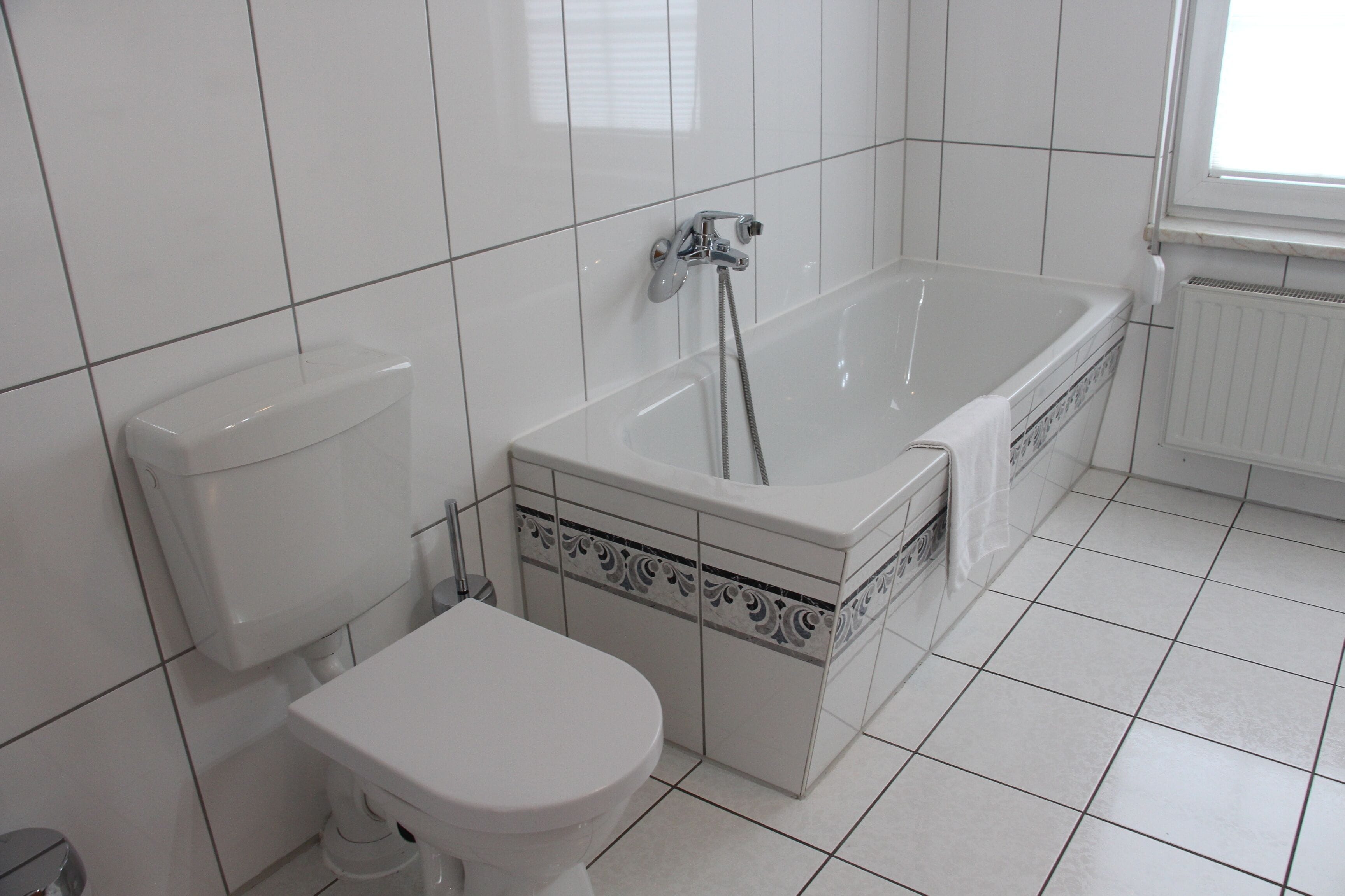 Un baño con inodoro, bañera y ventana.