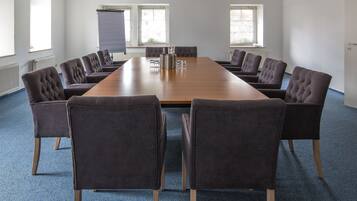 A conference room with a long table and eight upholstered chairs.