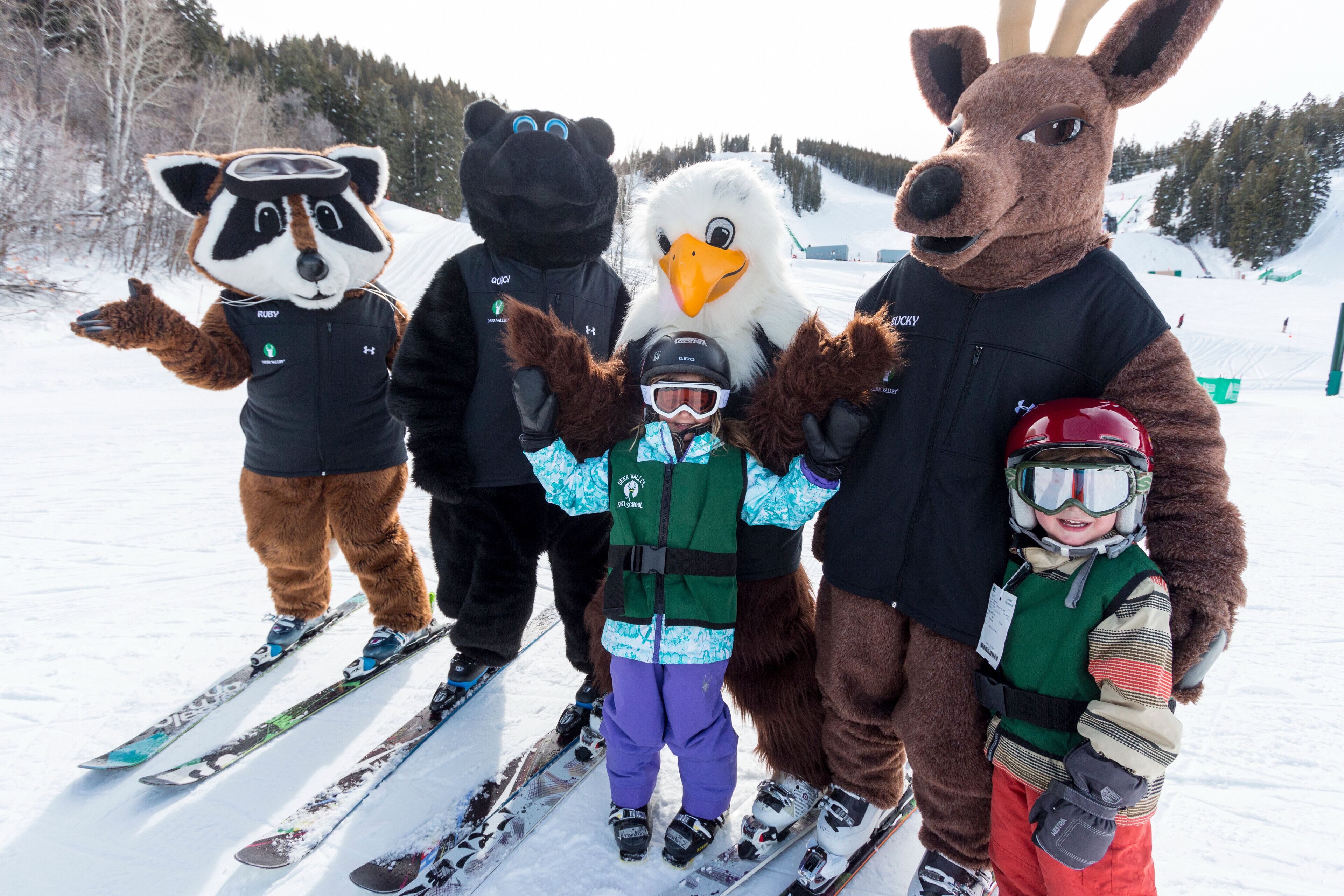 A group of people on skis with animal mascots.