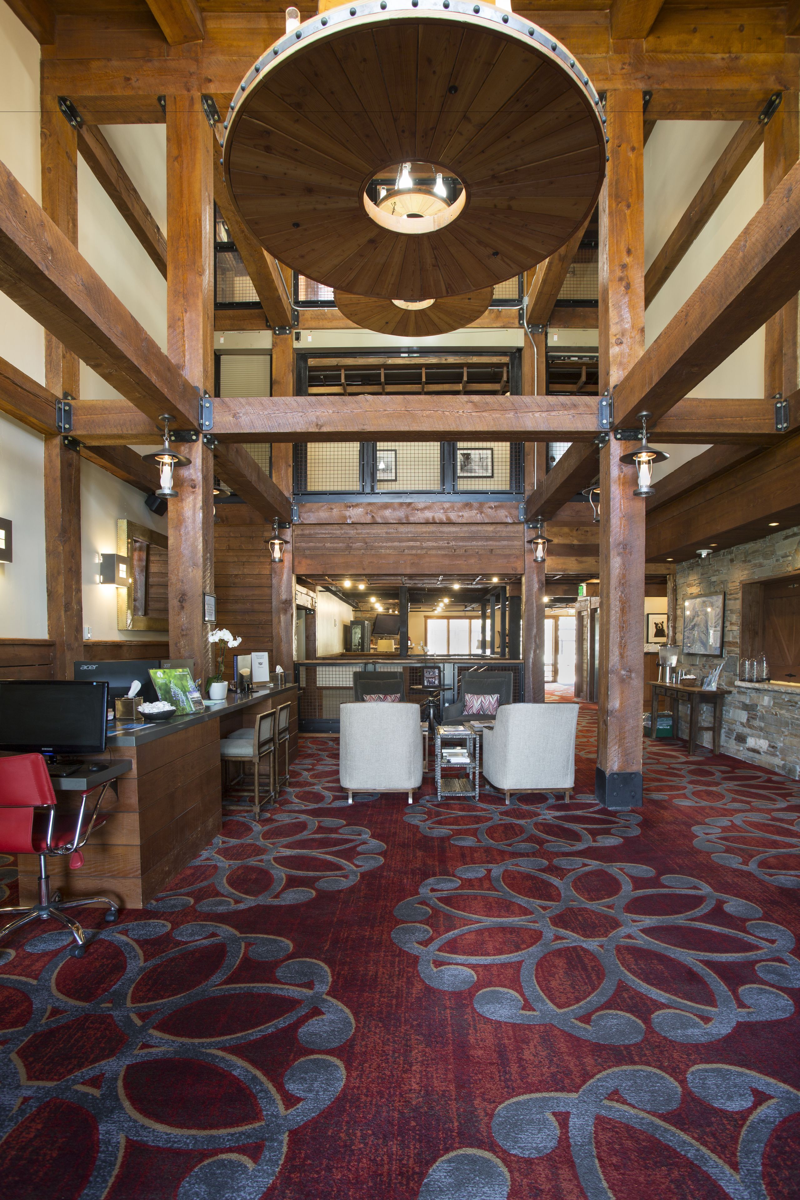 A spacious lobby with a high ceiling, wooden beams, and a patterned carpet.