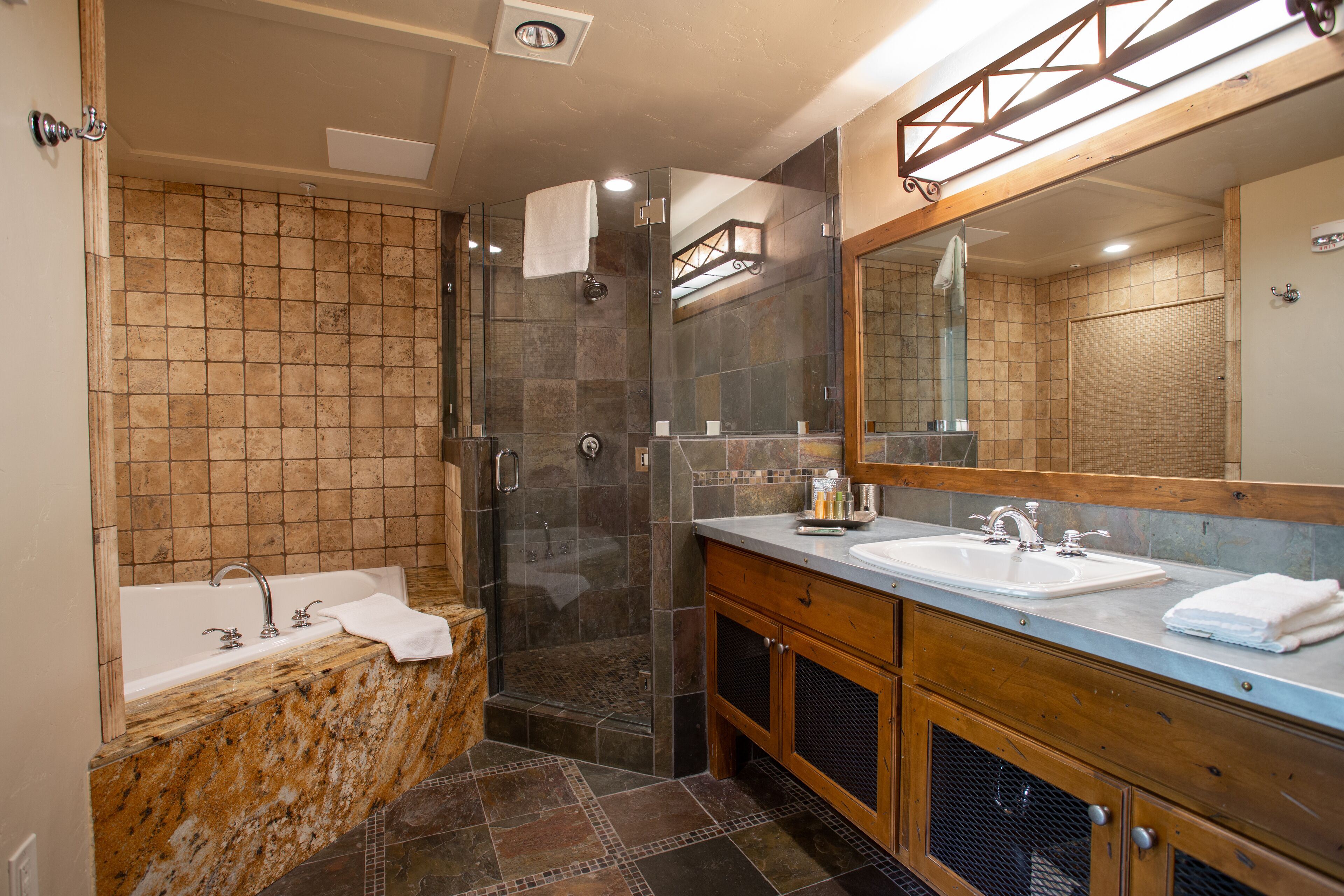 A modern bathroom with a glass-enclosed shower, two sinks, and a large mirror.