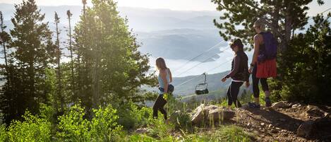 A group of people hiking on a trail with a mountain view in the background.