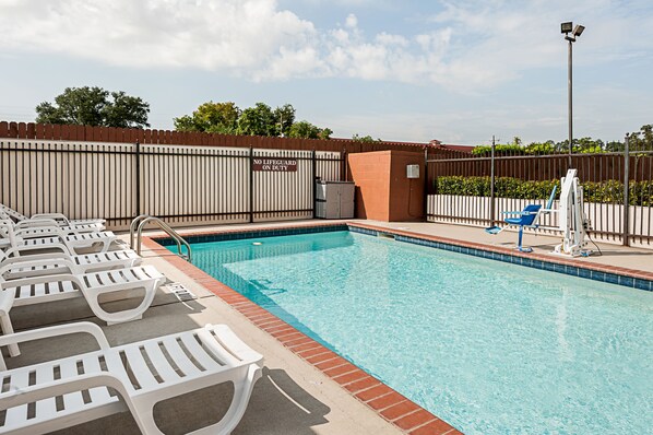 A swimming pool with lounge chairs and a lifeguard stand. - Comfort Suites Lake Charles (Lake Charles)