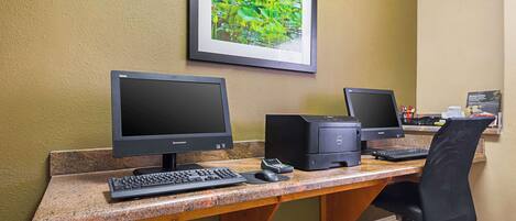 A computer desk with two monitors, a keyboard, a mouse, and a printer.