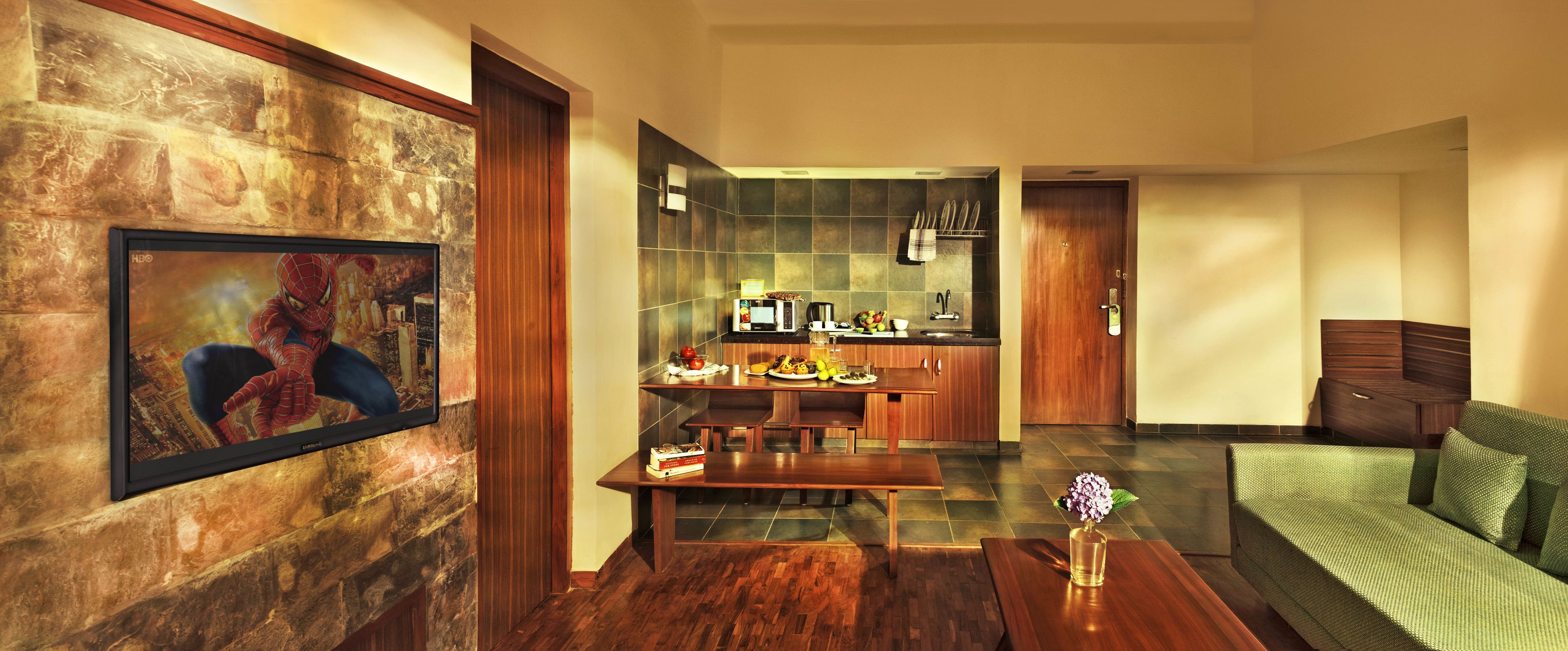 A modern living room with a wooden coffee table, a sofa, and a dining area with a kitchen in the background.