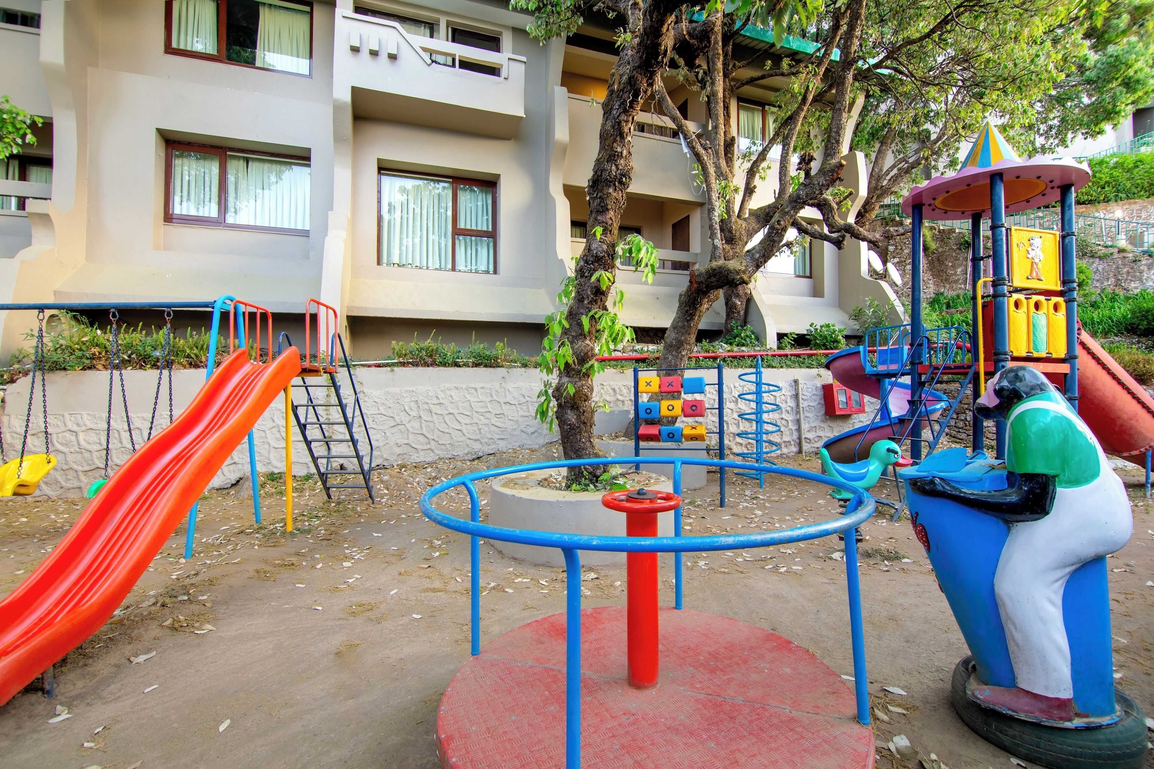 Ein Spielplatz mit Rutsche, Schaukeln und einer Kletterkonstruktion.