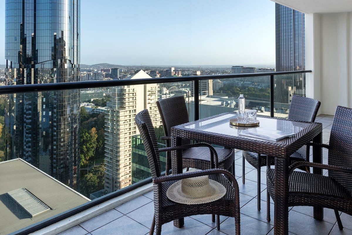 Ein Balkon mit Tisch und Stühlen und Blick auf die Stadt.