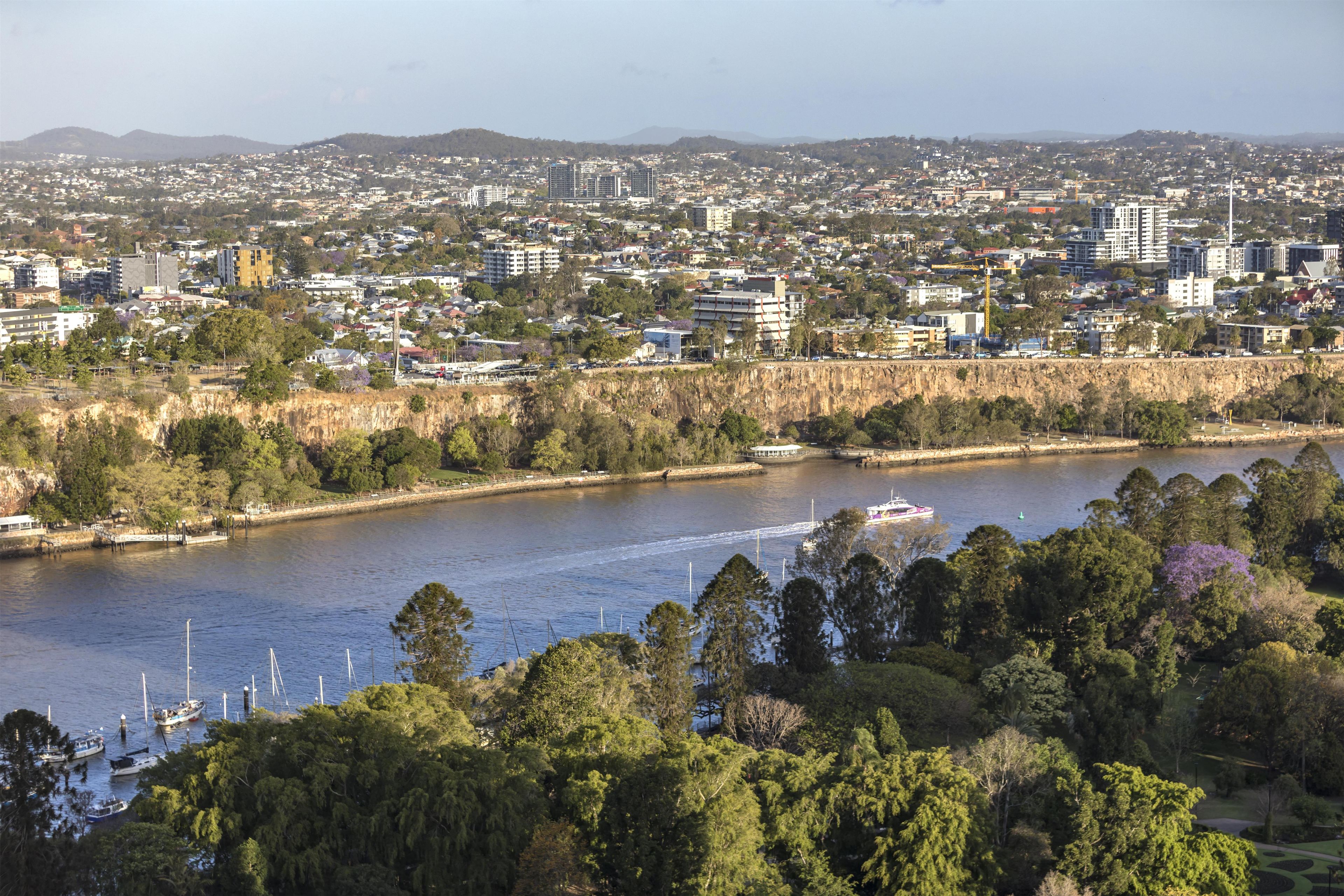 A river with boats, a bridge, and a cityscape in the background.