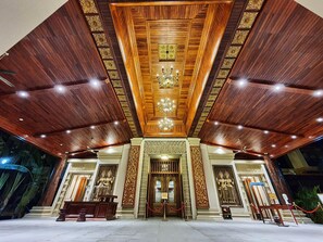 Uma entrada imponente com teto de madeira e detalhes entalhados.