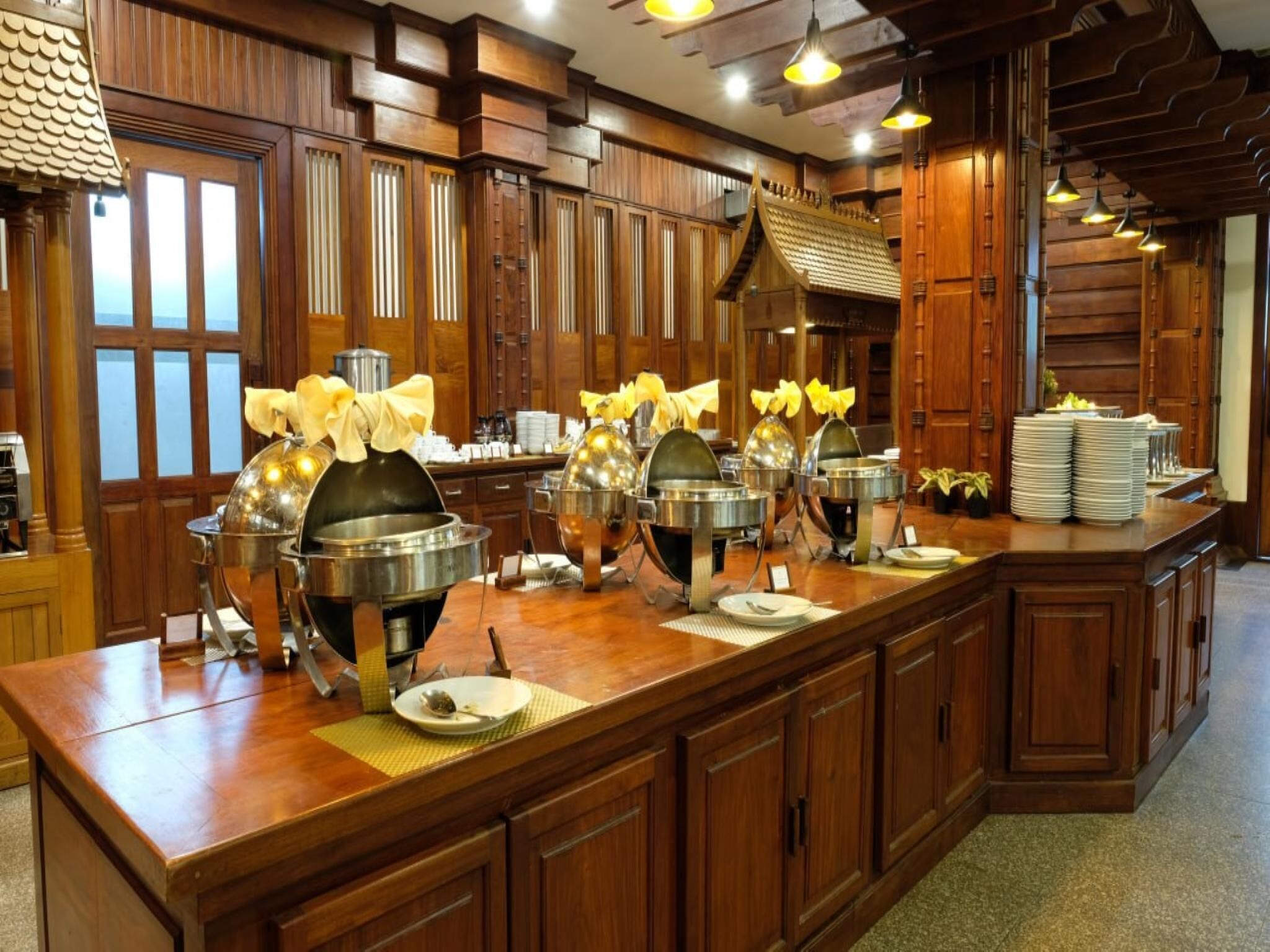 Un buffet disposé avec plusieurs points de service, des panneaux de bois et un grand miroir qui reflète la pièce.
