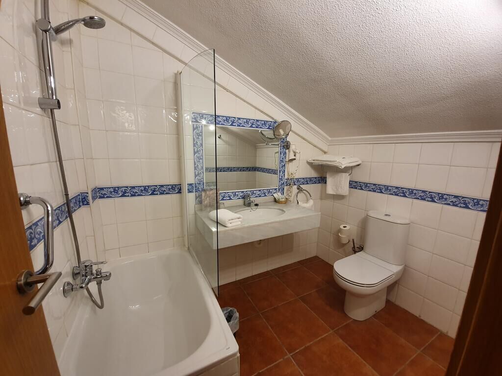 Un baño con bañera, inodoro y lavamanos.