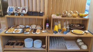 Un bufé de desayuno con una variedad de alimentos y bebidas.