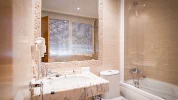 A bathroom with a marble sink, a toilet, and a bathtub.