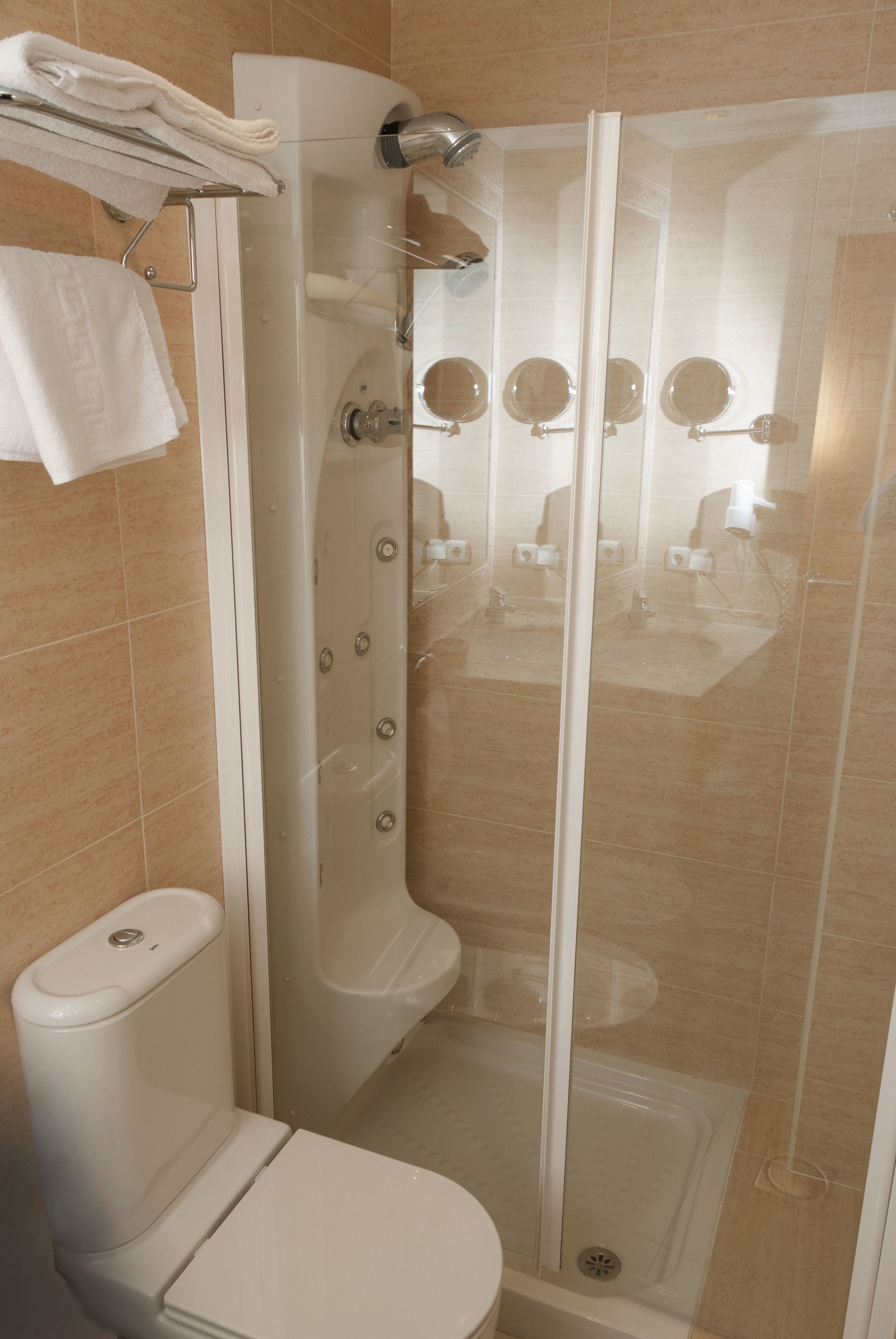 Un baño moderno con ducha de vidrio, inodoro y lavamanos.