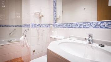 A modern bathroom with a large sink, a shower, and a toilet.