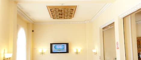 A hotel lobby with a large stained glass ceiling, a reception desk, and multiple seating areas.