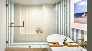 Un baño con ducha, bañera y pared de azulejos.