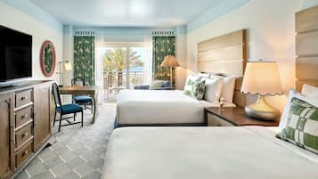 Habitación de hotel con dos camas, un escritorio, un televisor y vistas al exterior.