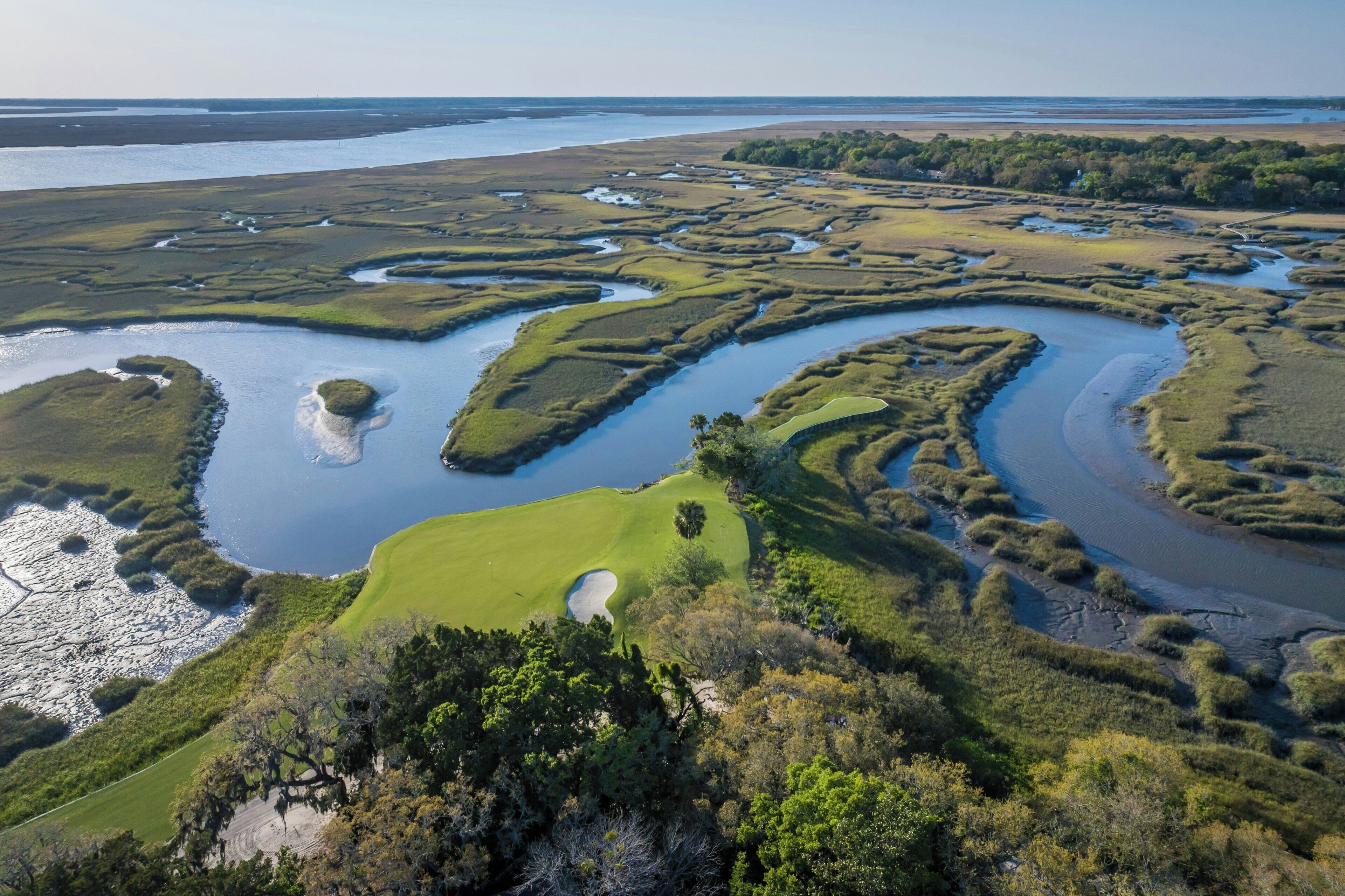 An aerial view of a golf course with multiple water bodies and green areas.