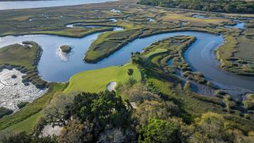An aerial view of a golf course with multiple water bodies and green areas.