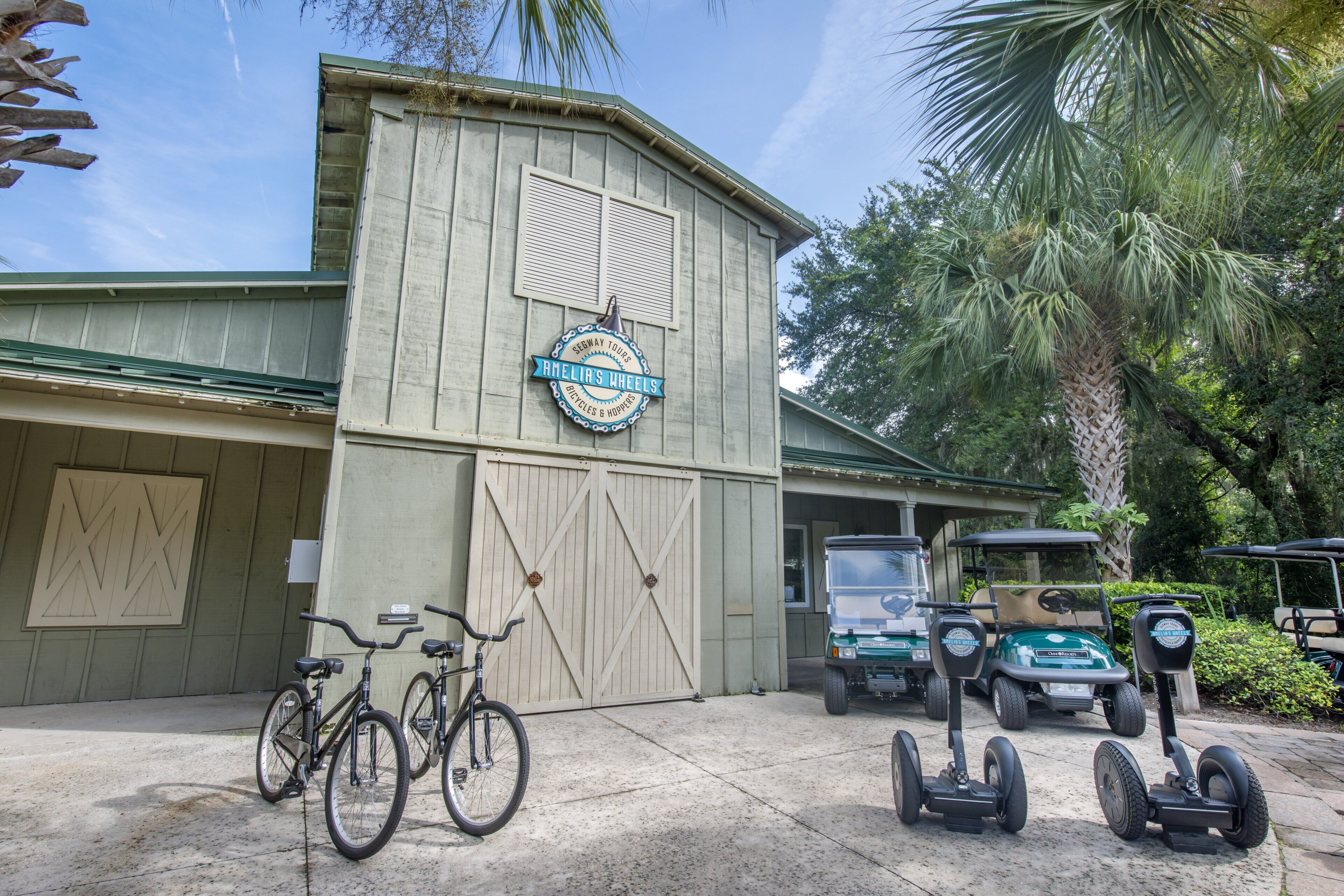 A building with a sign for Segway Tours, bicycles, and golf carts parked outside.