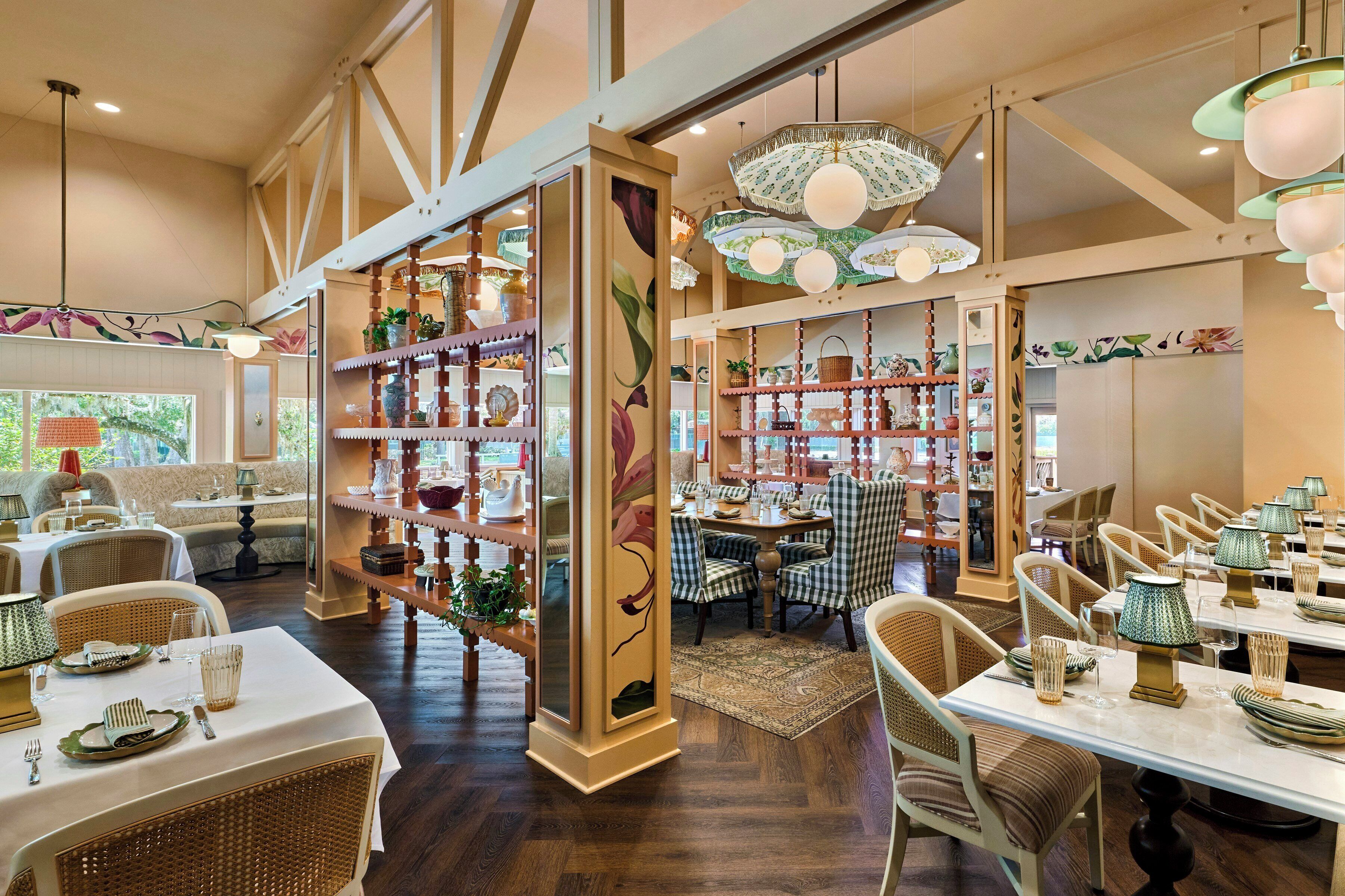 A restaurant with high ceilings, exposed beams, and a variety of seating options including tables and chairs.