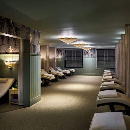 A spa room with massage chairs, a reception area, and a wall with a floral mural.