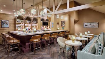 A bar area with a bar counter, stools, and hanging spherical light fixtures.