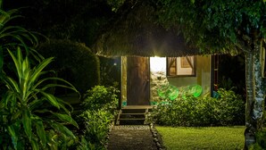 A thatched-roof structure with a wooden door and steps leading to a small porch. - Picocanoa Rodavento (Jalcomulco)