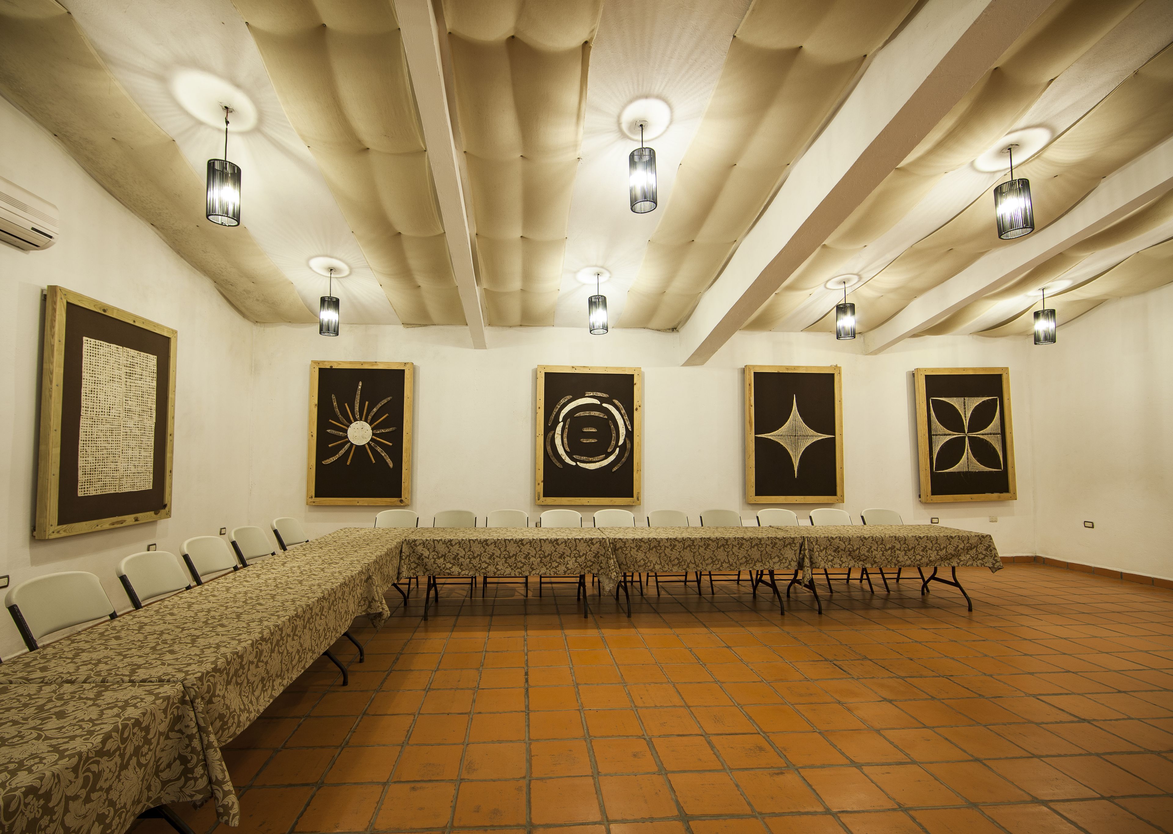 A conference room with a long table, chairs, and ceiling lights.