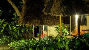 A thatched-roof structure with chairs and a small porch area surrounded by lush greenery. - Picocanoa Rodavento (Jalcomulco)