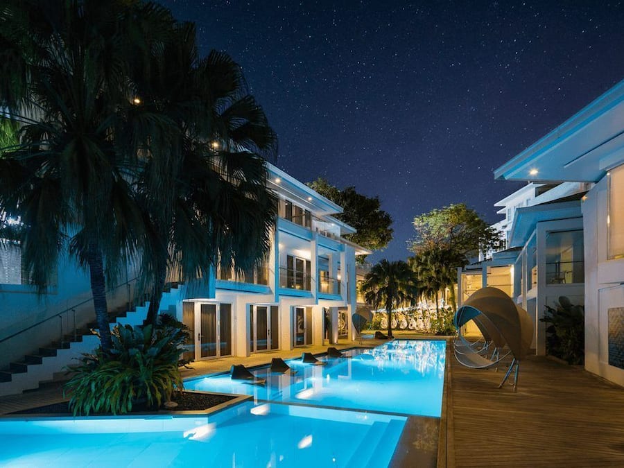 Una piscina al aire libre, sombrillas, sillones reclinables de piscina