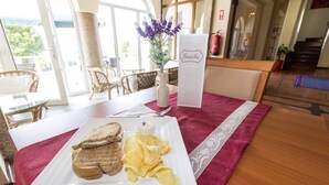 Een eethoek met een tafel gedekt voor een maaltijd, inclusief brood, chips en een klein schaaltje saus.