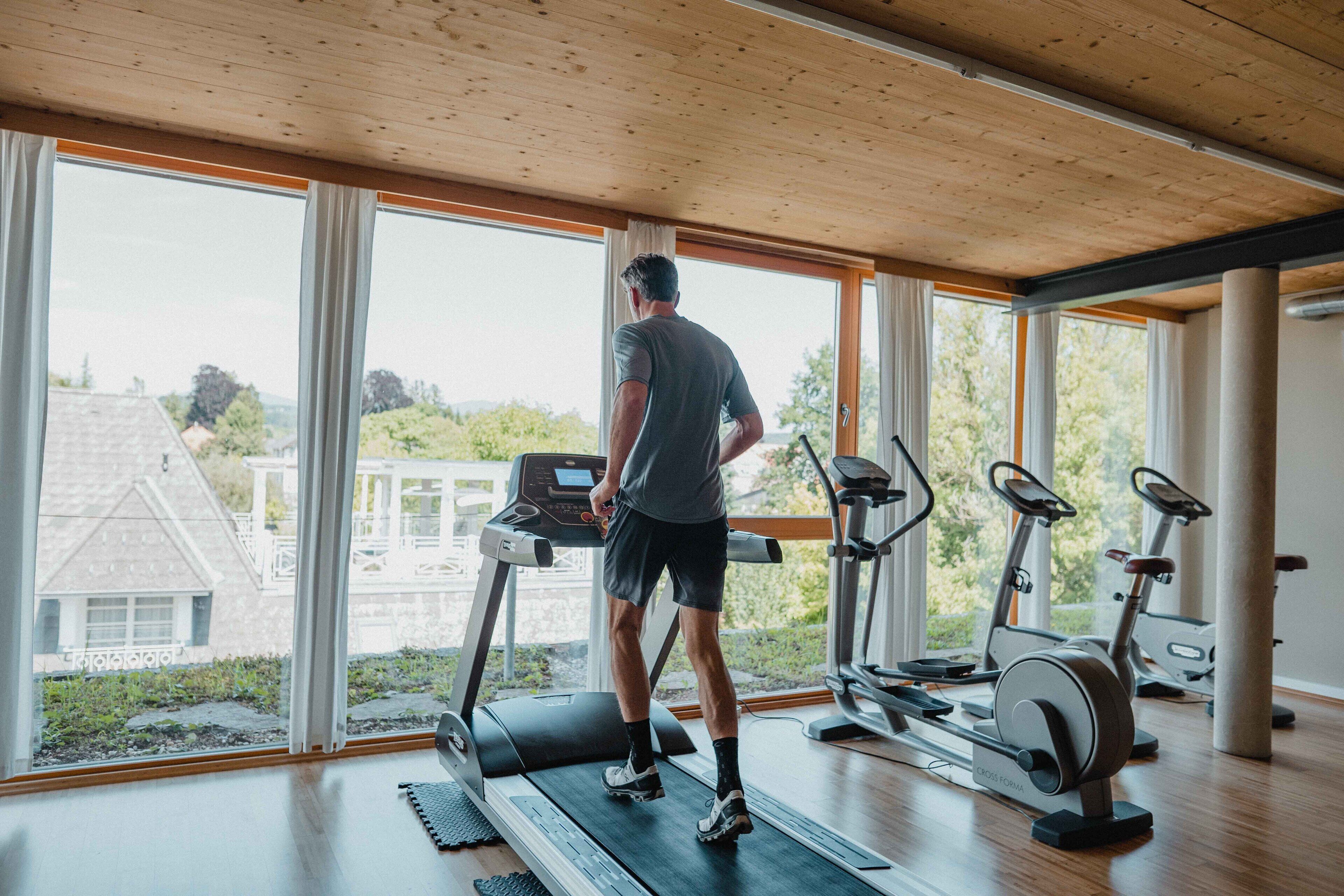 A gym with a treadmill, stationary bikes, and a rowing machine.