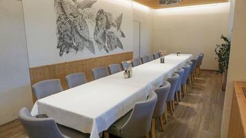A conference room with a long table, chairs, and a projector.
