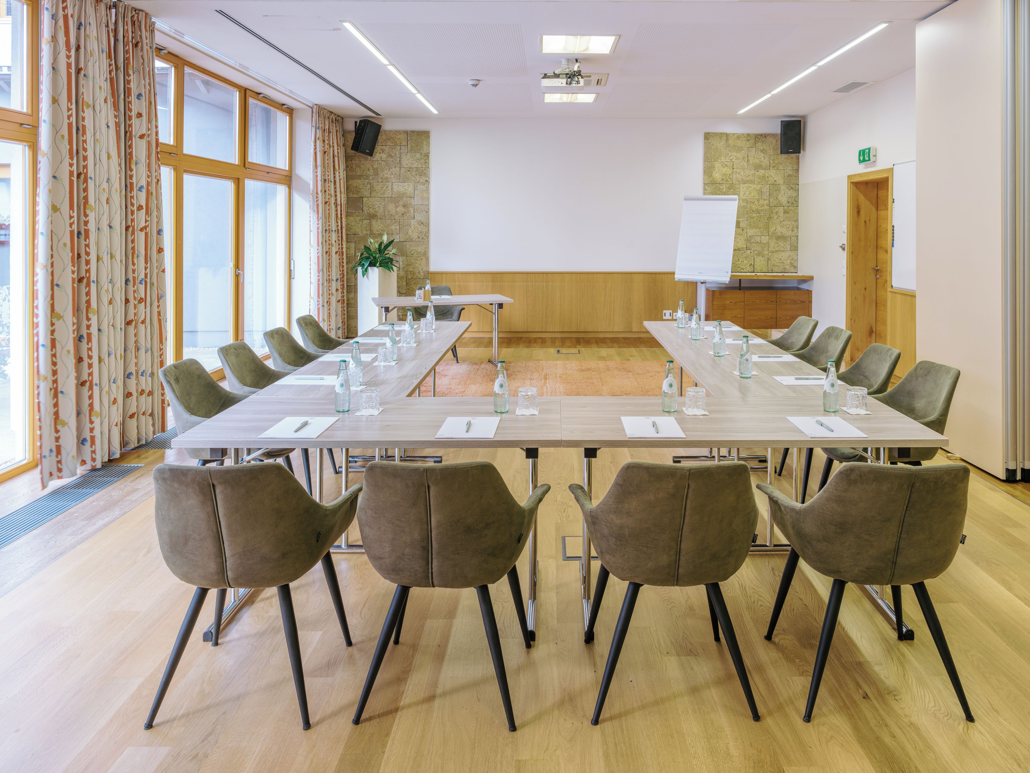 Una sala de conferencias con una larga mesa, sillas y una pizarra.