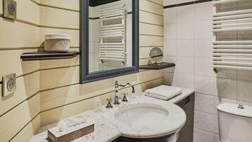 A bathroom with a sink, mirror, towel, and a shower.