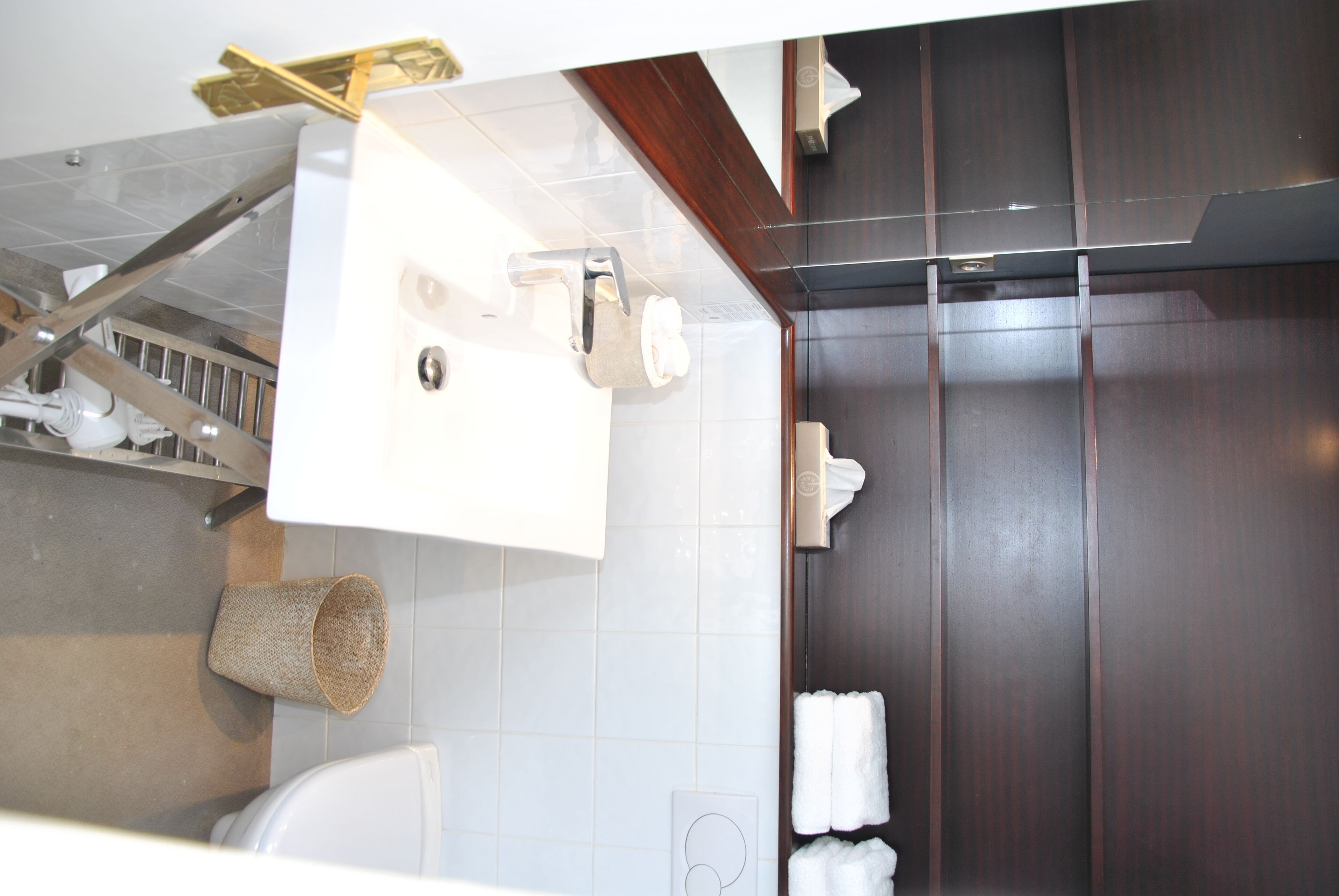Een badkamer met een wit wastafel, toilet en handdoekhouder.