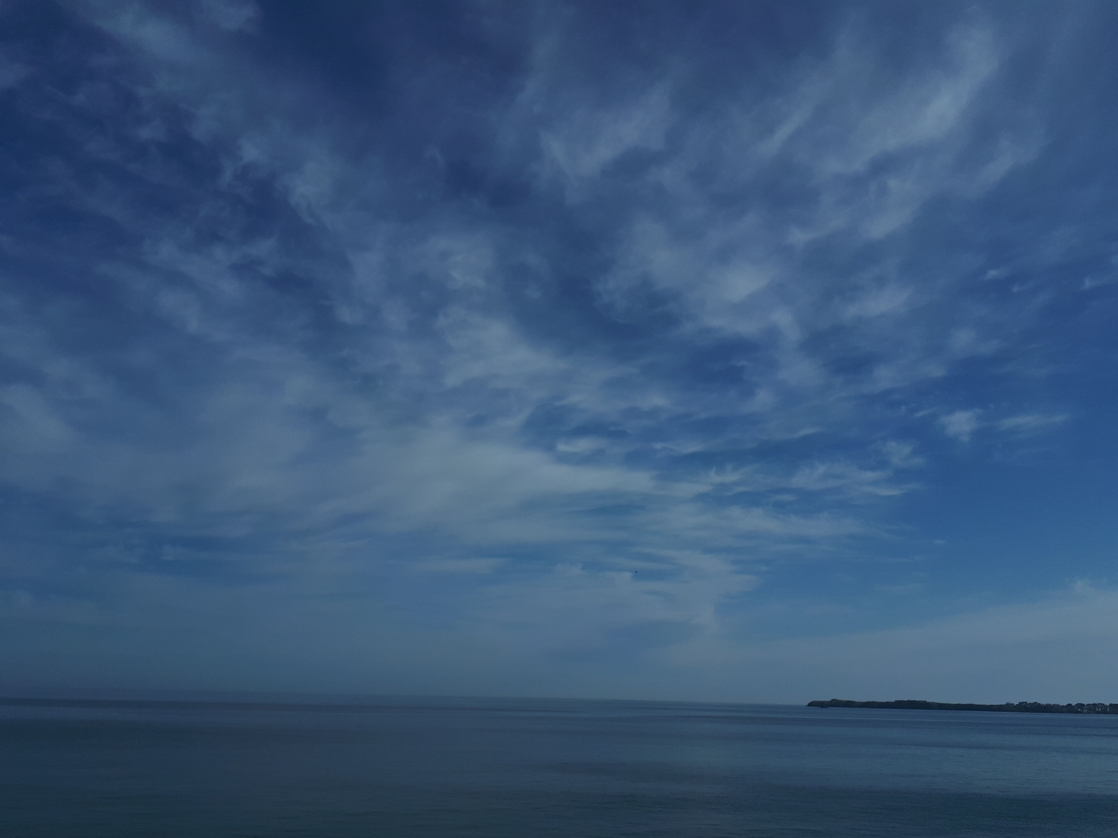 Vista costera con cielo despejado y mar en calma.