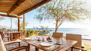A wooden table set for dining with a view of the sea. - Dahab Paradise (Dahab)