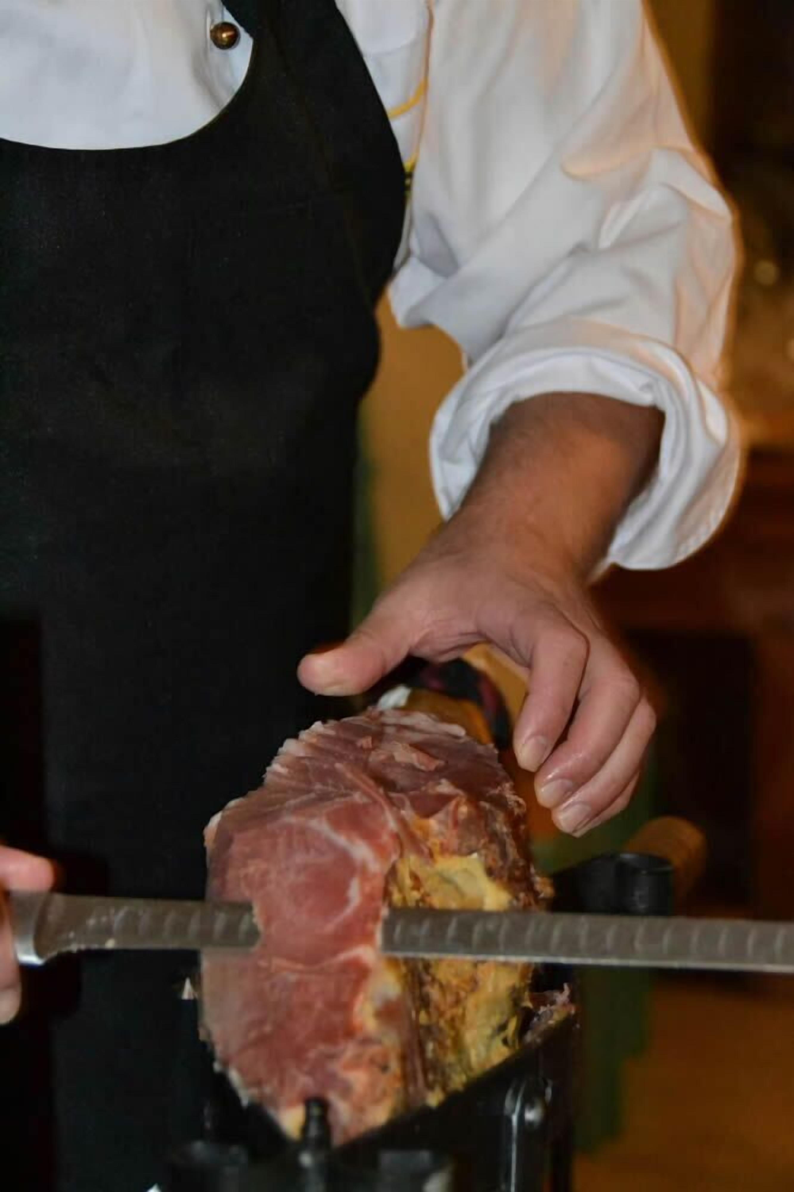 Una persona che affetta la carne su uno spiedo rotante.