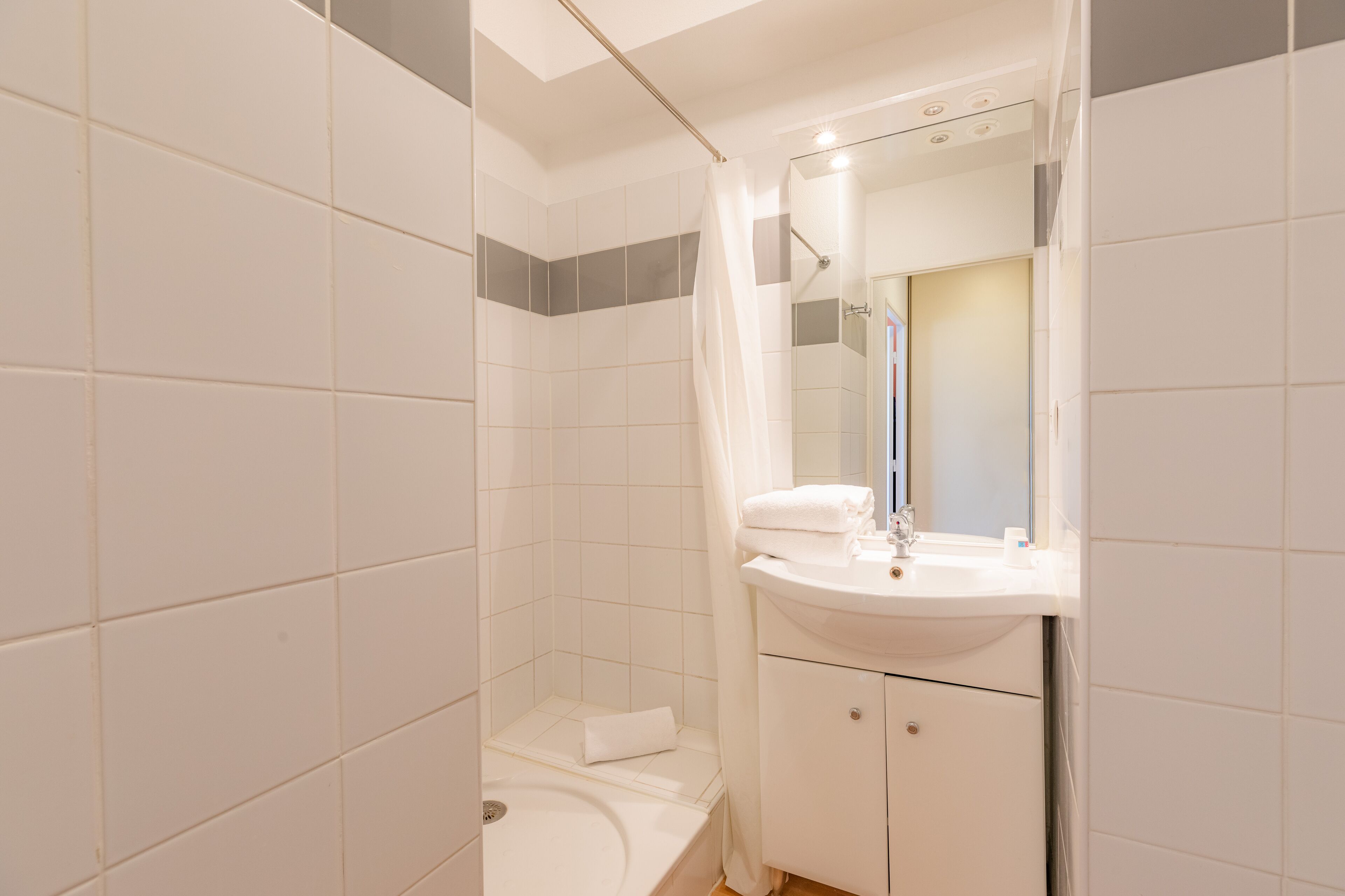 Une salle de bain avec une baignoire, un lavabo et un miroir.